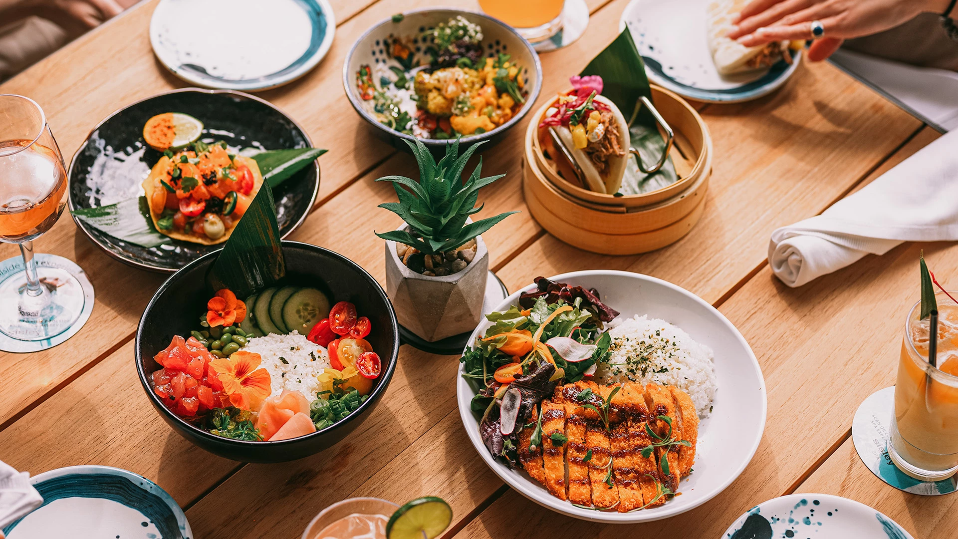 A table set with various dishes of food and glasses of drinks.