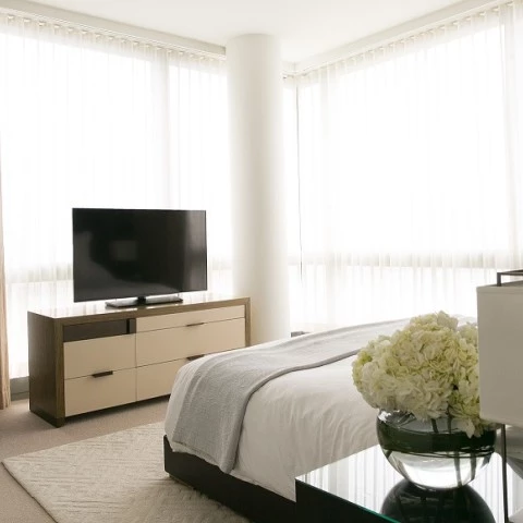 a bedroom with a tv and a vase of flowers