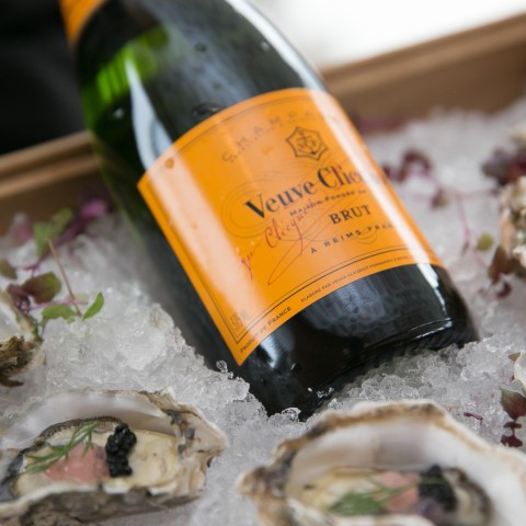 a bottle of champagne and oysters on ice