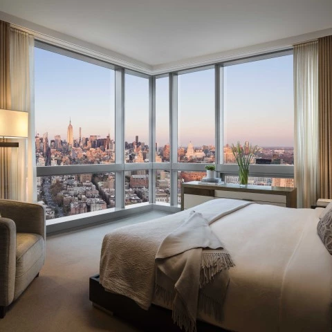 a bedroom with a view of a city