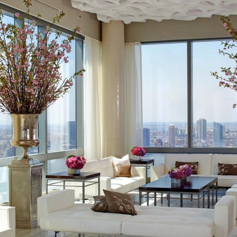 a room with white furniture and a large vase of flowers