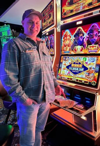 a man standing in front of a slot machine