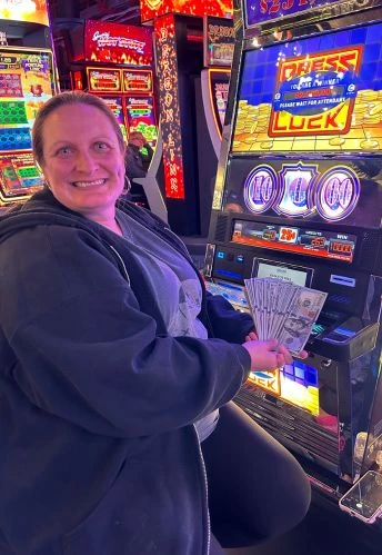 a woman holding money in front of a slot machine