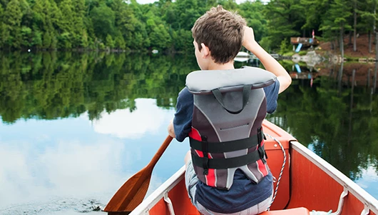 young boy rowing in a kayak