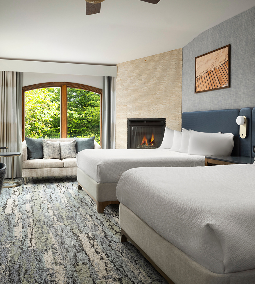 a room with two beds and a fireplace