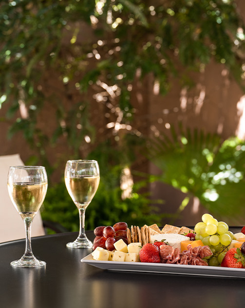 a plate of food and glasses of wine on a table