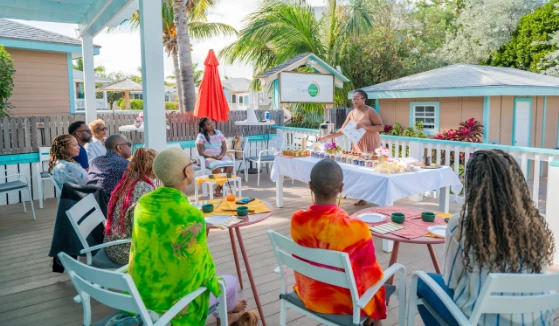 a woman speaking to a group of people sitting around tables