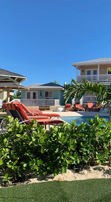 a pool with chairs and trees in front of it