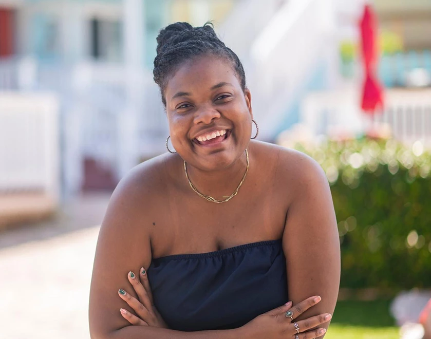 a woman smiling with her arms crossed