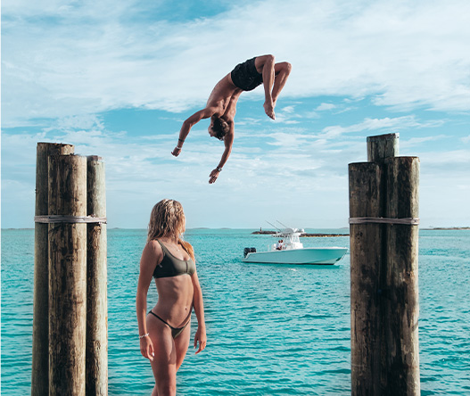 a man jumping into the air with a woman in the water