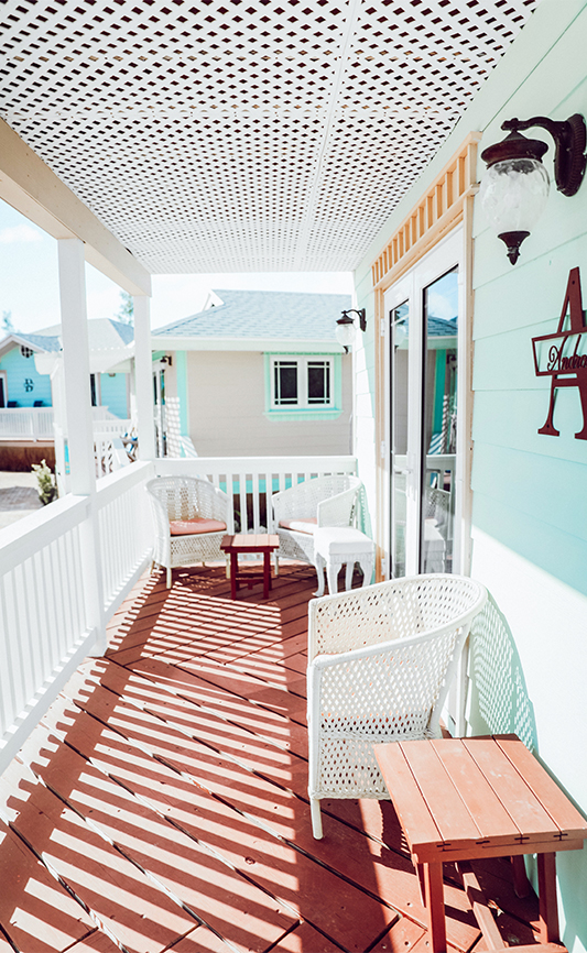 a porch with chairs and tables