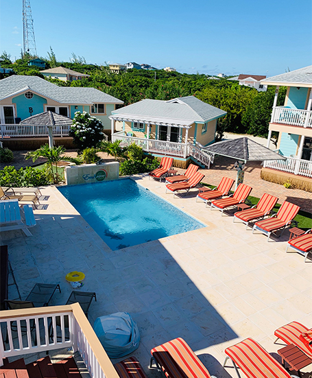 a pool and chairs in a resort
