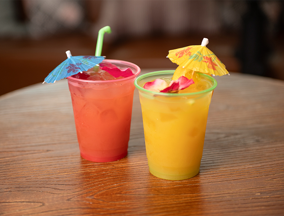 two cups of drinks with umbrellas on a table