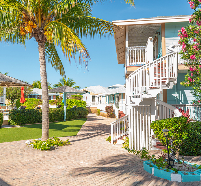 a brick walkway with a building and palm trees