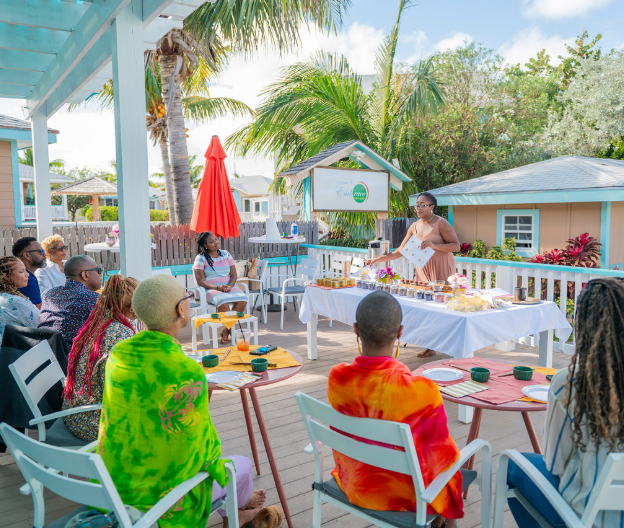 a woman giving a speech to a group of people sitting around a table