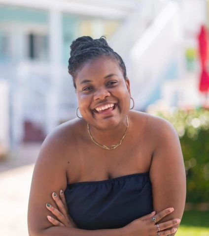 a woman smiling with her arms crossed