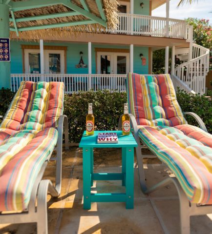 chairs on a patio with a table and a table with drinks