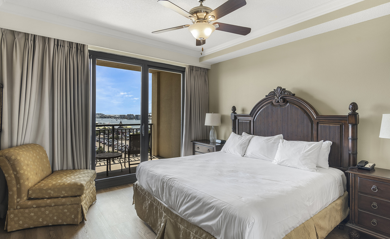 a bedroom with a large bed and a ceiling fan