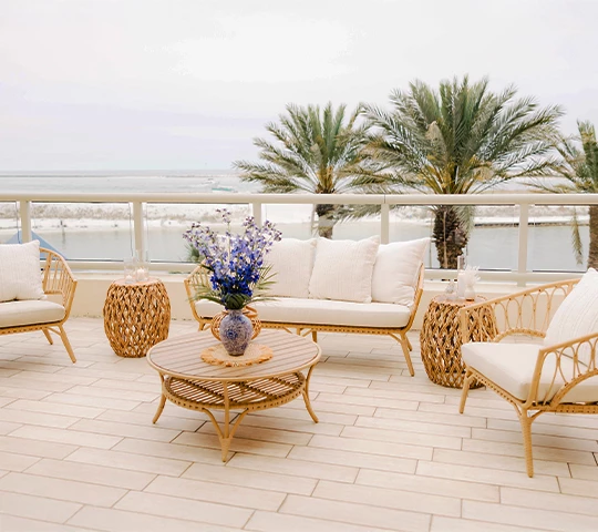 a patio with wicker furniture and a table