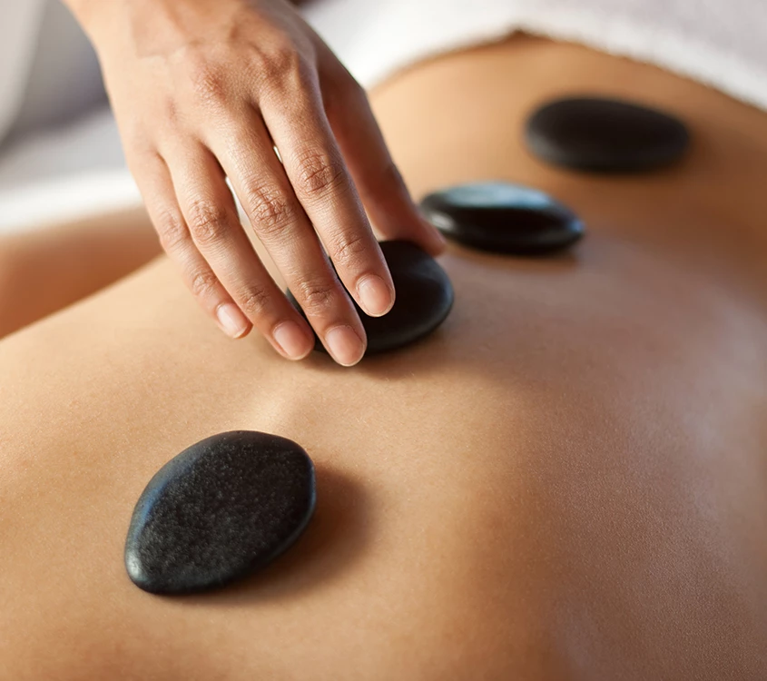 a person getting a hot stone massage