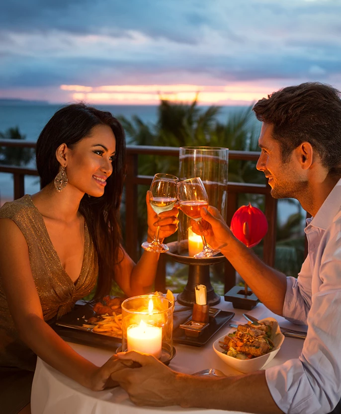 a man and woman sitting at a table with wine glasses