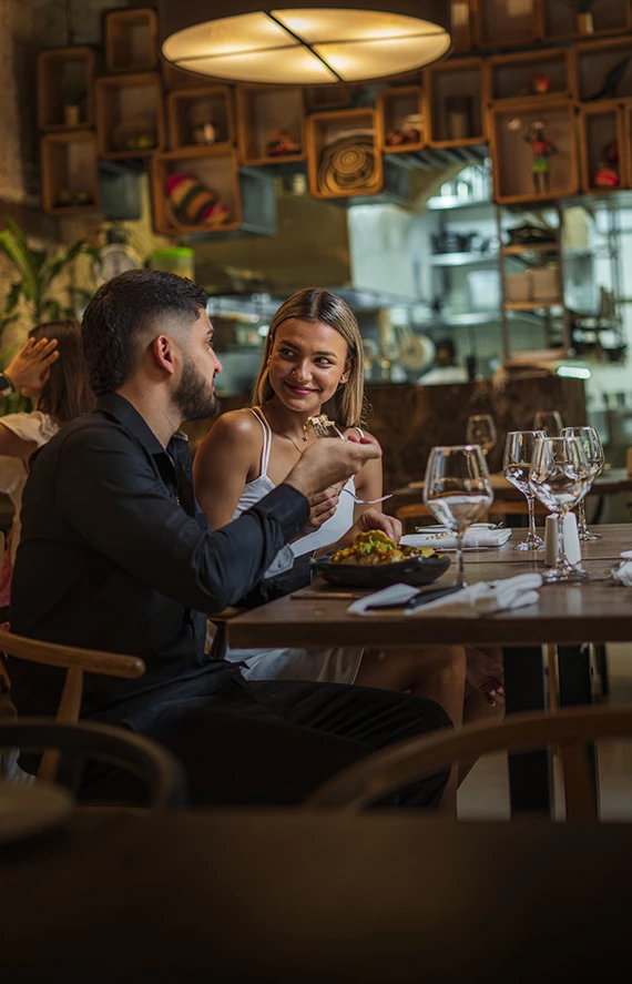 a man and woman sitting at a table eating food