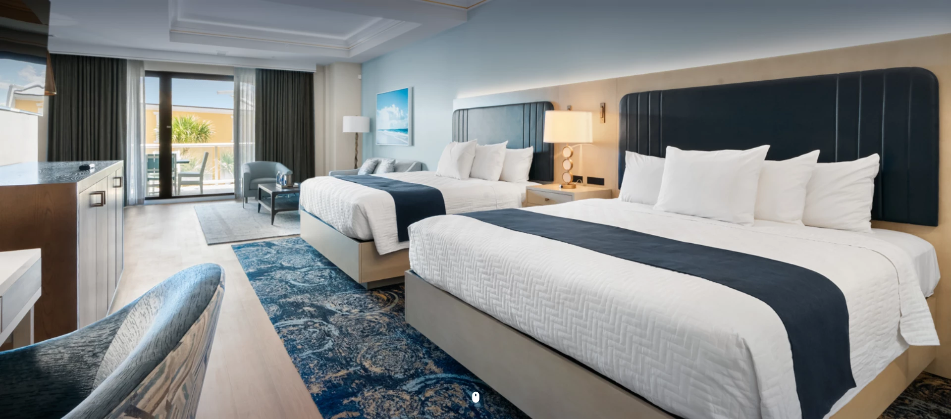 a room with two beds and a blue rug
