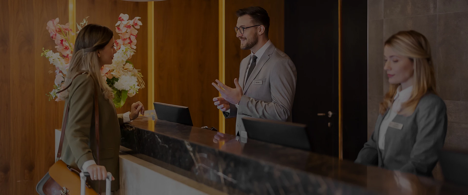 a man in a suit talking to a woman at a reception desk