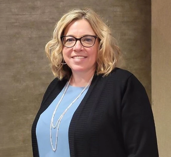 a woman wearing glasses and a black cardigan