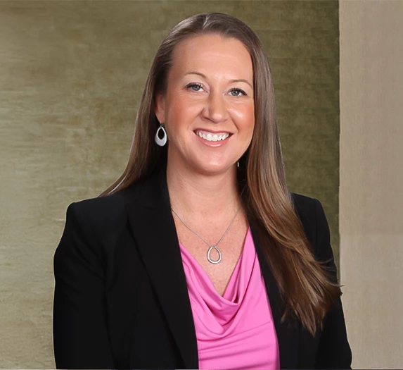a woman in a black blazer and pink shirt