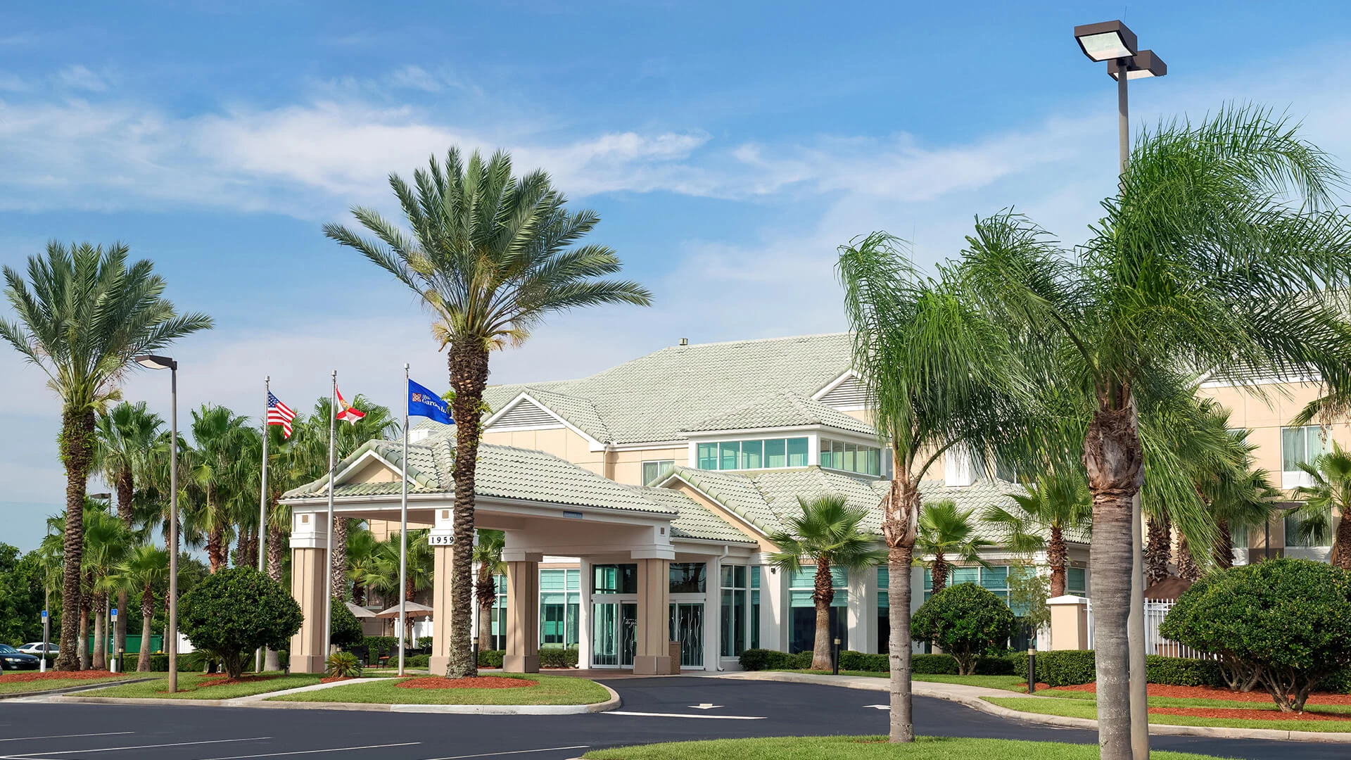 a building with palm trees and flags