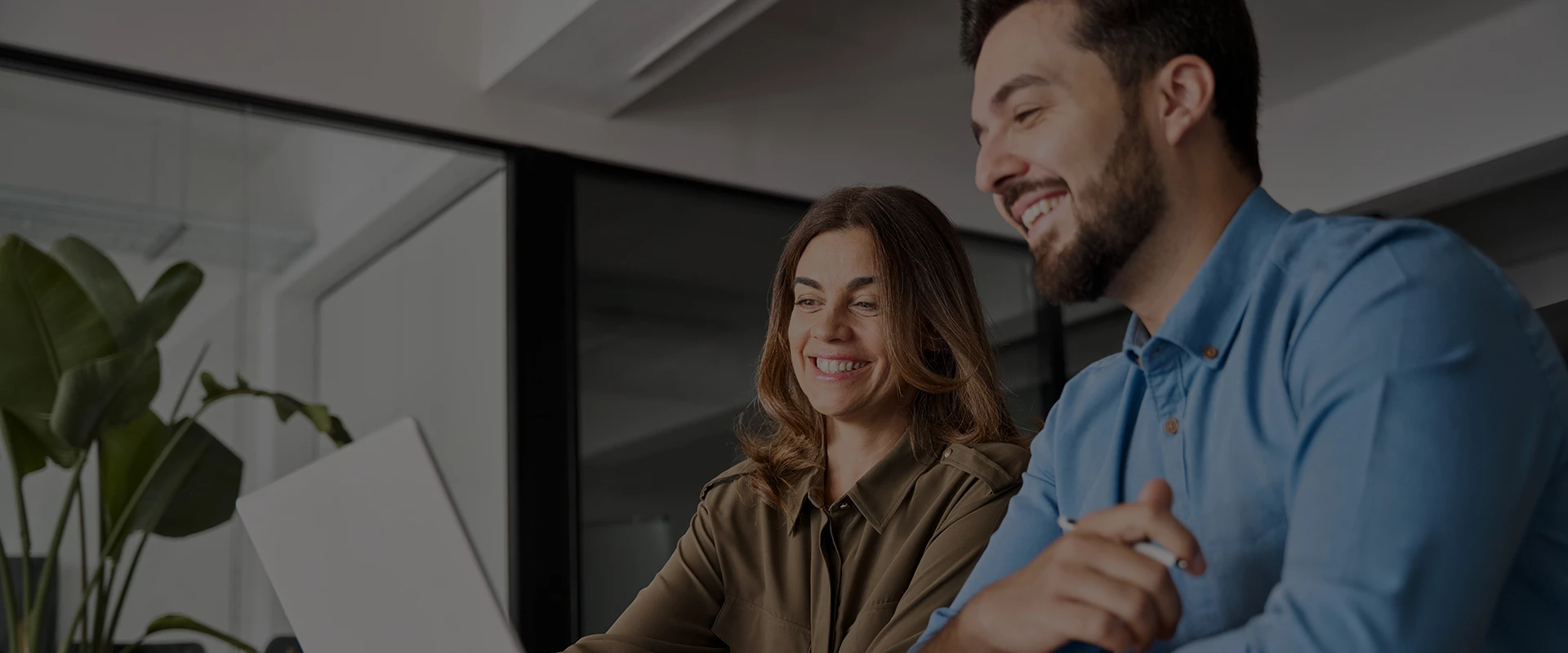a man and woman looking at a computer screen