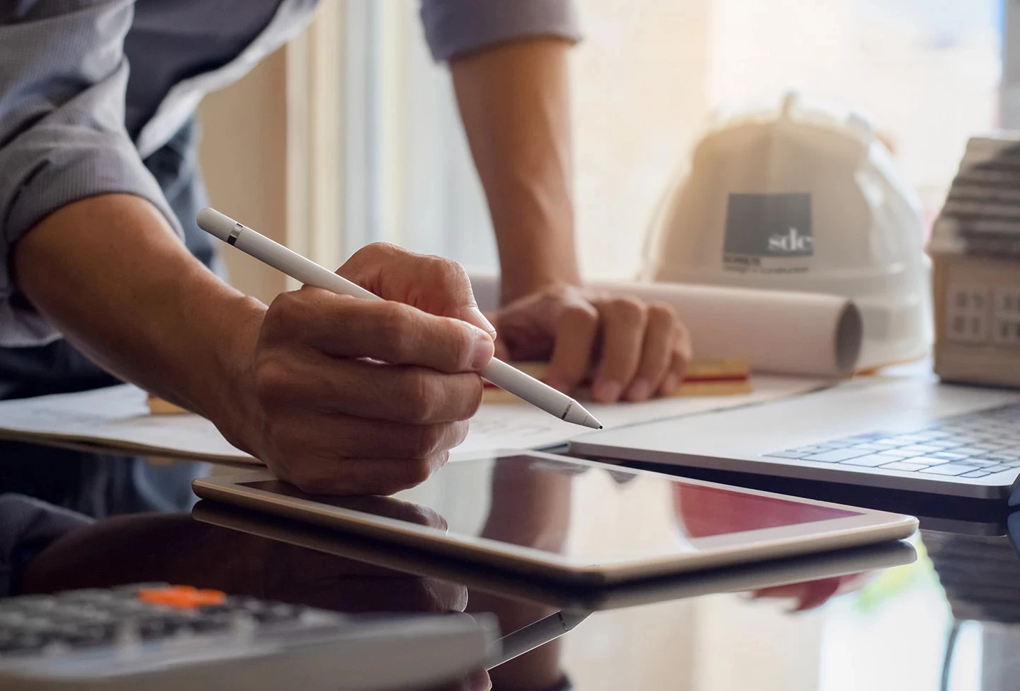 a person holding a stylus and a tablet