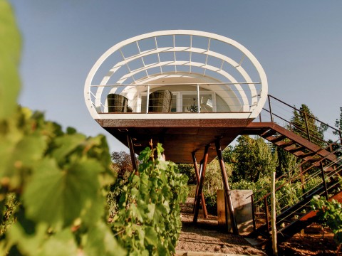 a house on stilts with a balcony and stairs