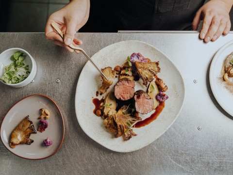 a plate of food with a person holding a fork