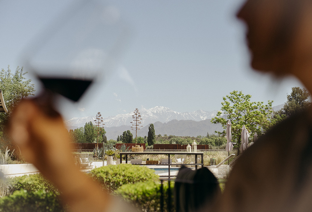 a group of people looking at a pool with a mountain in the background