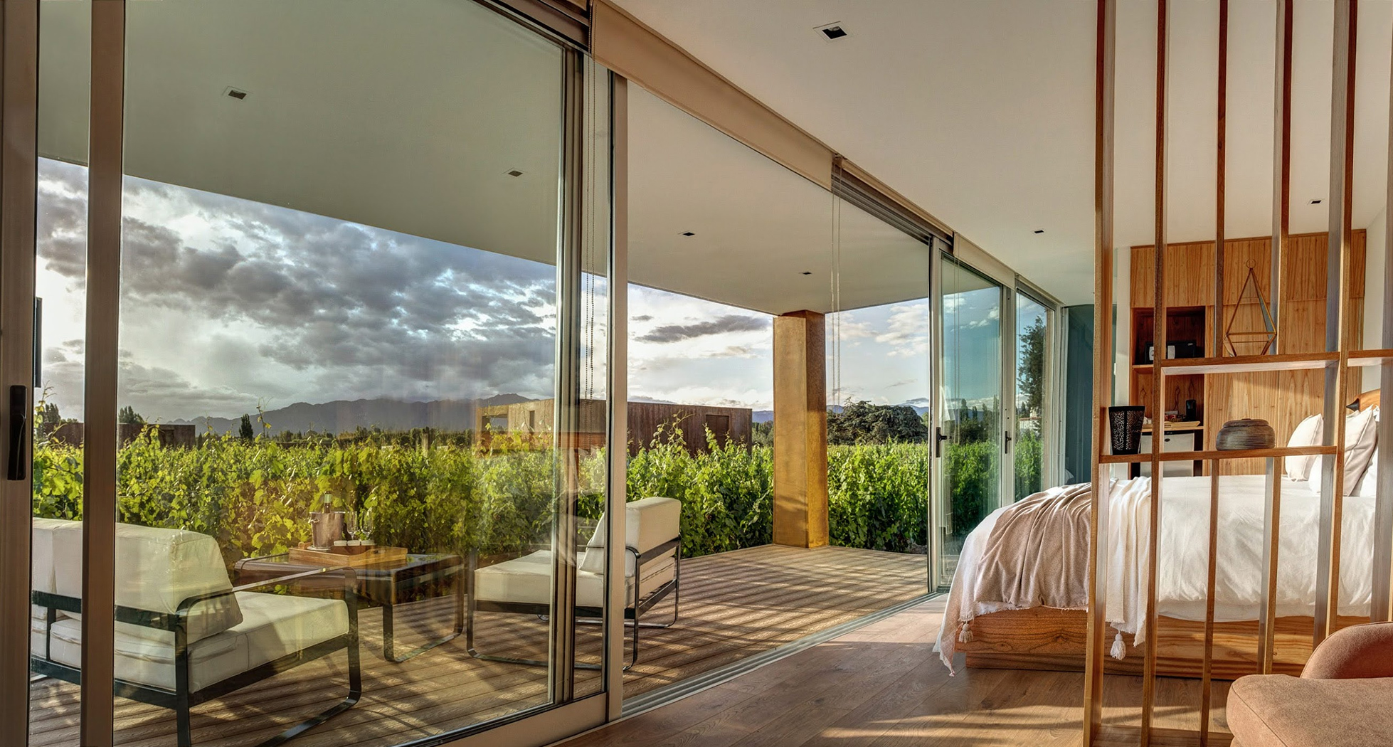 a bedroom with glass doors and a table and chairs