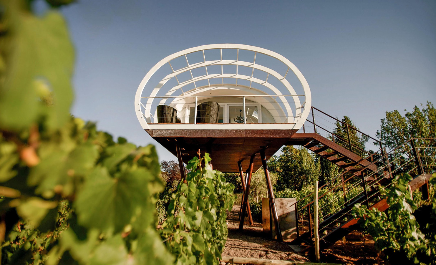a house on stilts with stairs and plants