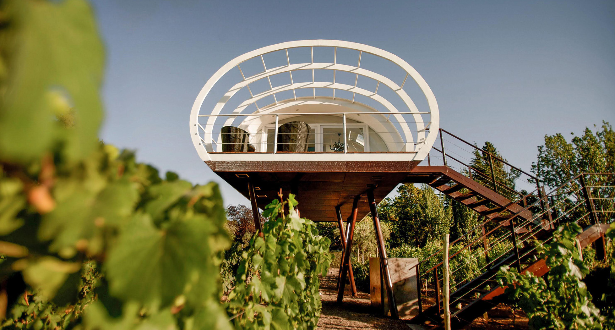 a house on stilts with plants in the background