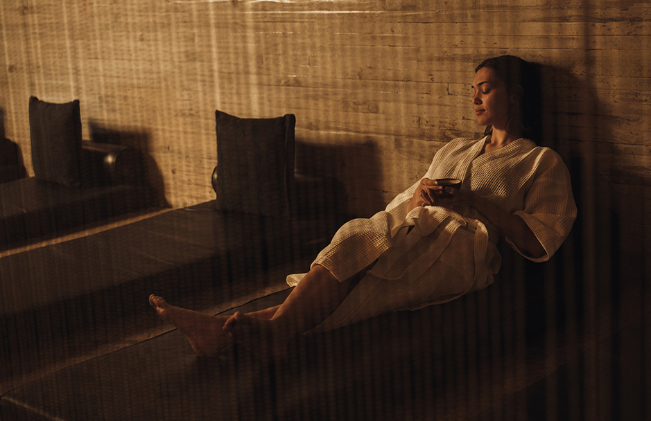 a woman in a bathrobe sitting on a bench