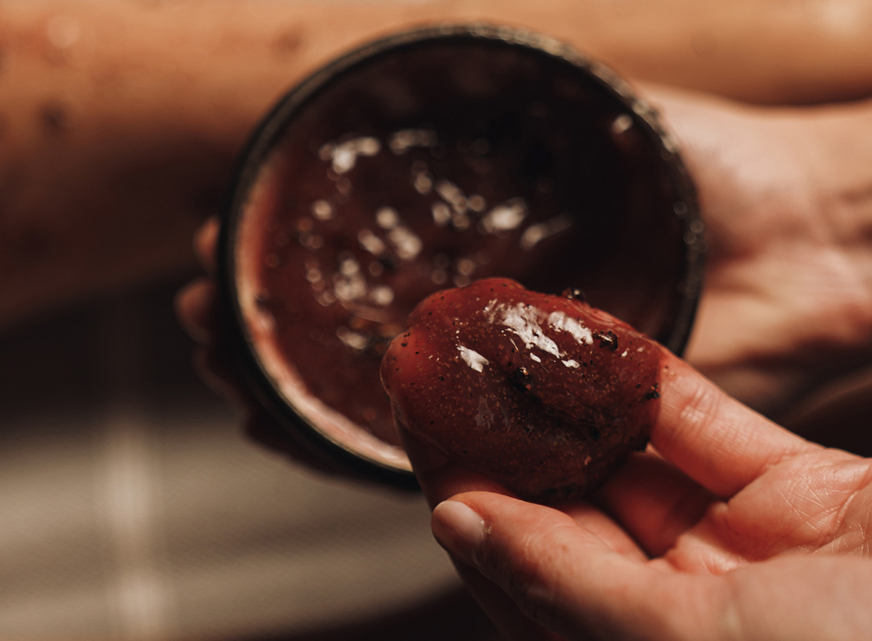 a person holding a bowl of red sauce