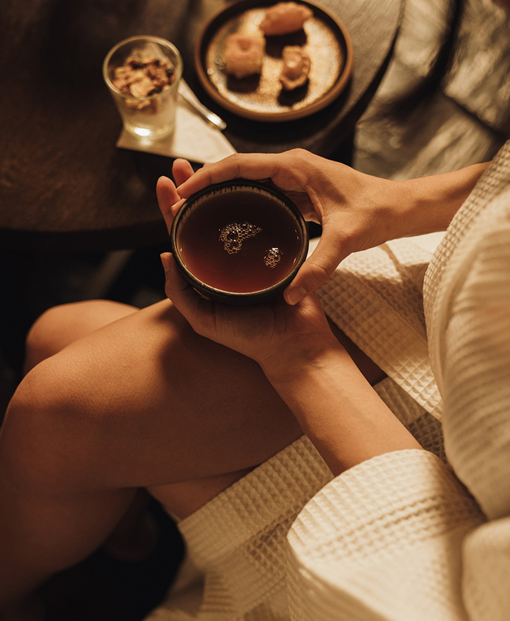 a person in a robe holding a cup of tea