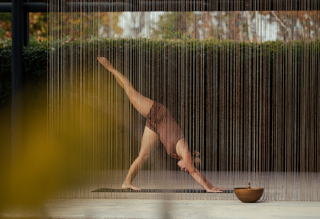 a woman doing yoga in front of curtain