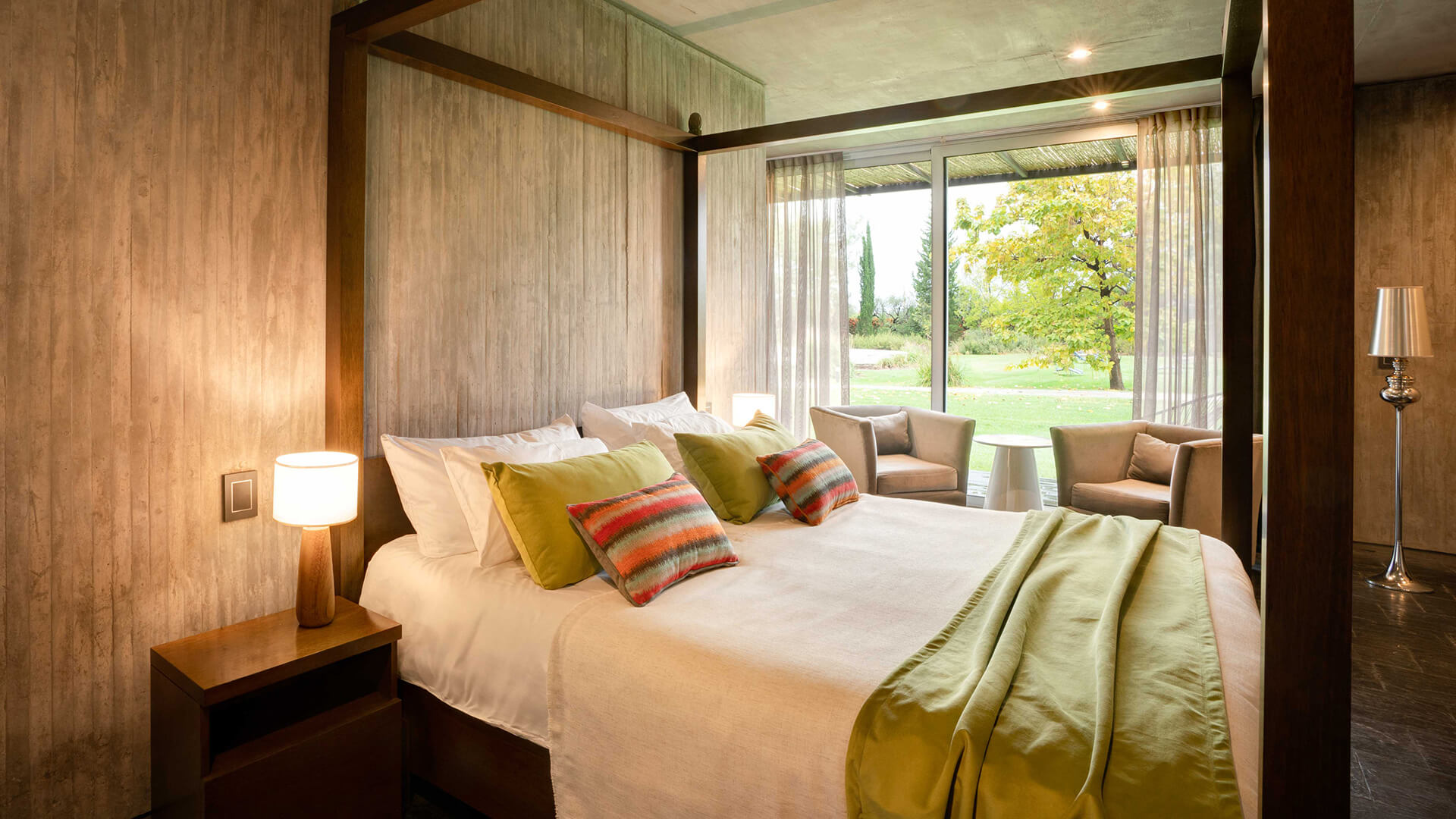 a bed with pillows and a lamp next to a window