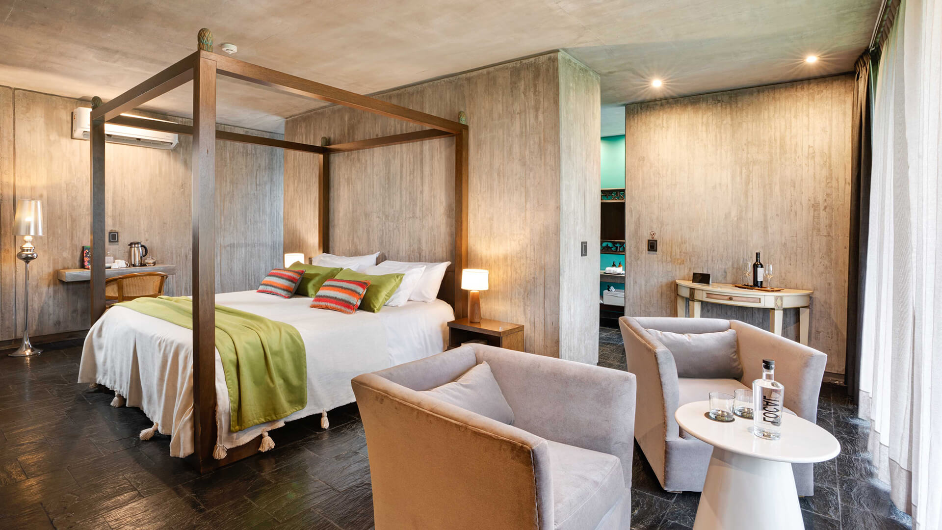 a room with a bed and chairs