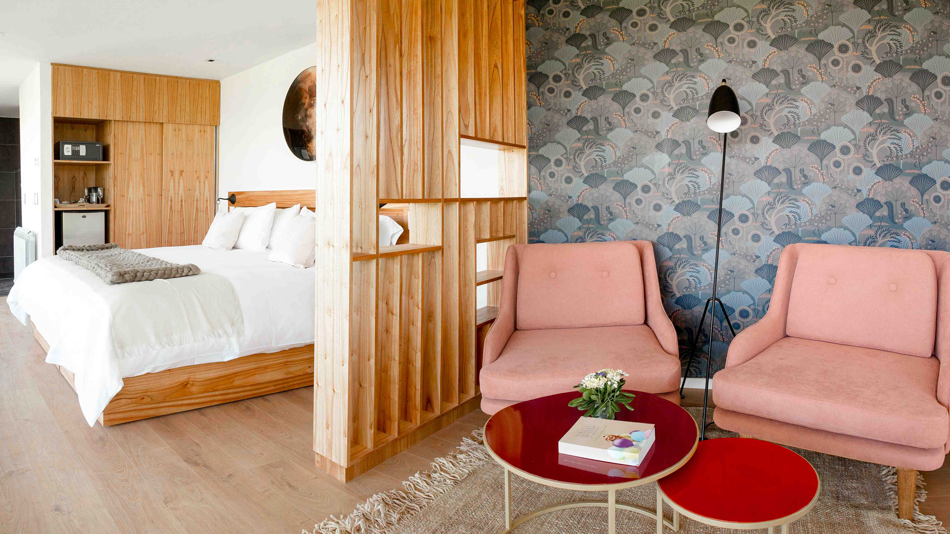 a room with a bed and chairs