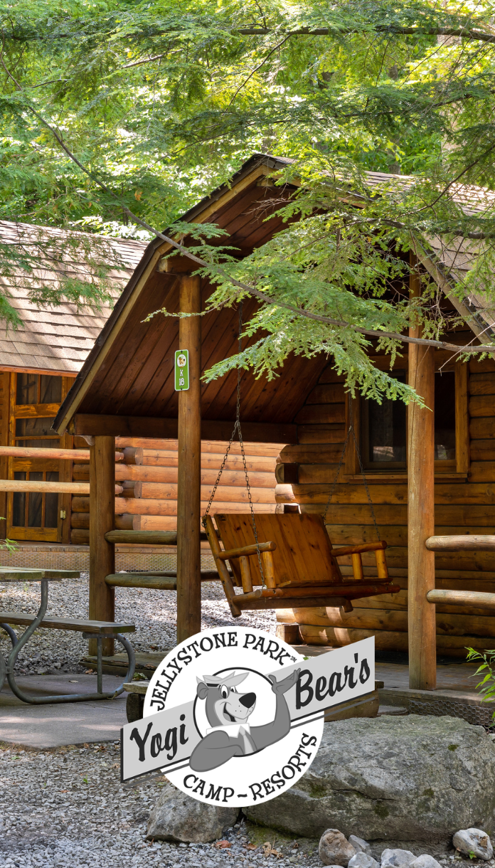 a wooden swing in front of a log cabin