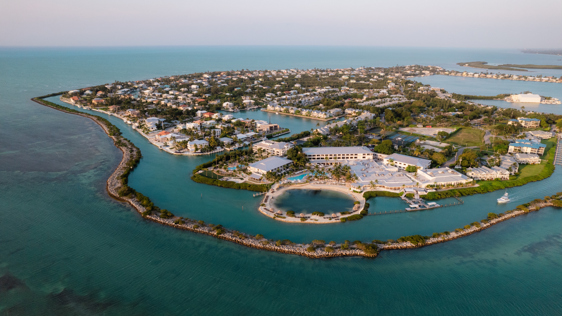 a aerial view of a small island with buildings and a pool