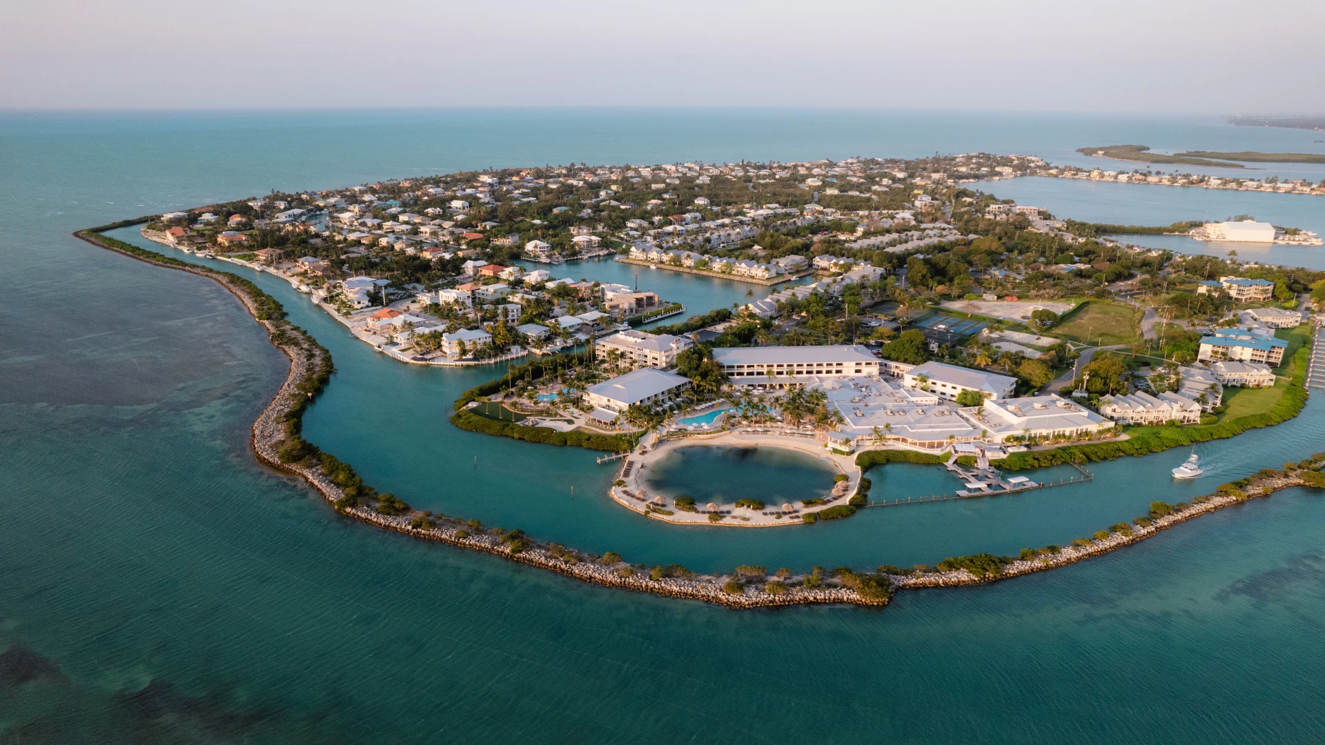 a aerial view of a small island with buildings and a pool