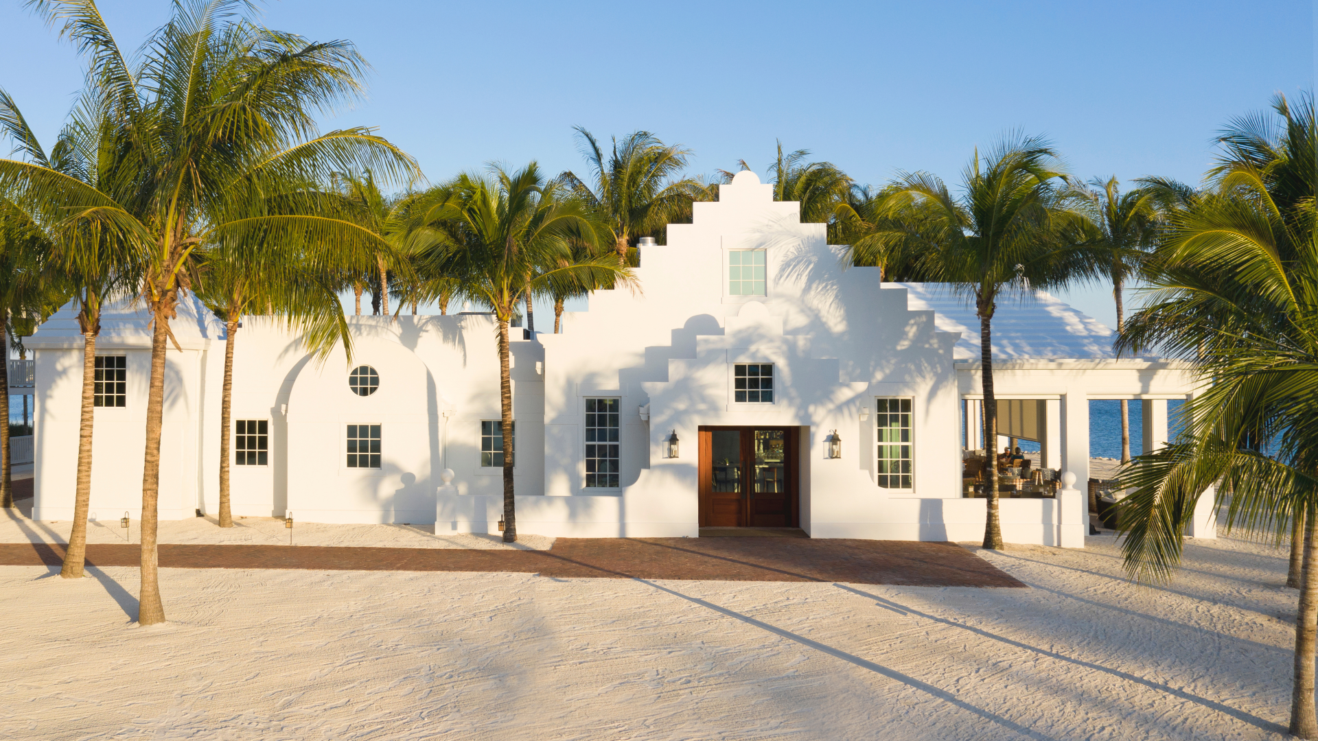 a white building with palm trees